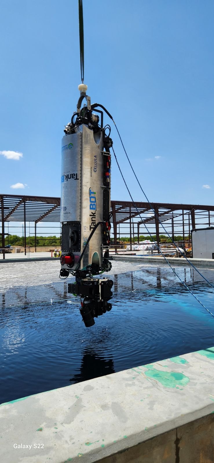 Agellus tank-inspection robot hanging vertically from a lifting line above a pool.